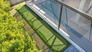 A rooftop garden with a swimming pool, artificial grass, and a fence. - Marco Island Escape Pool Game Room (Marco Island)