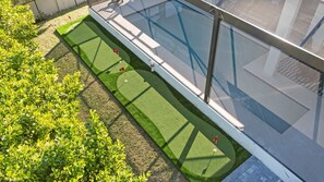 A rooftop garden with a swimming pool, artificial grass, and a fence. - Marco Island Escape Pool Game Room (Marco Island)