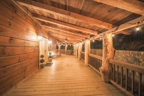 A wooden covered porch with a stone wall, wooden railings, and a wooden floor. - Sleeps 16 Hot Tub Sauna Dogs Welcome Ping Pong (Mars Hill)