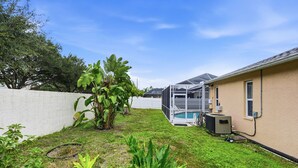 A residential backyard with a swimming pool, a covered patio, and a house with an attached garage. - Heated Pool Game Room Outdoor Fun Sleeps 6 (Tampa)