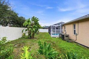 Ein Wohngrundstück mit Swimmingpool, überdachter Terrasse und einem Haus mit angebauter Garage.