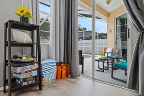 A hotel room with a large window, a bookshelf, a small table with snacks, and a view of the outside. - Heated Pool Game Room Outdoor Fun Sleeps 6 (Tampa)