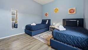 A bedroom with two beds, a ceiling fan, and a mirror. - Heated Pool Game Room Outdoor Fun Sleeps 6 (Tampa)