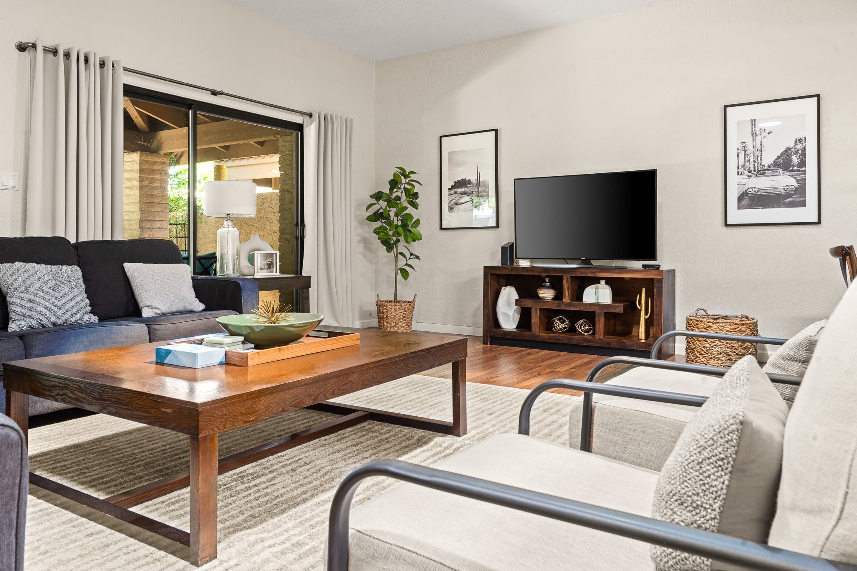 A living room with a sofa, coffee table, TV, and decorative items.