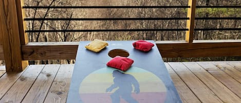 Una terraza de madera con una mesa que presenta un diseño colorido y cojines.