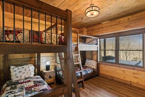 A cabin with a loft bed, a lower bunk bed, and a desk with a lamp. - Stunning Views Sleeps 10 - Hot Tub - 2 Fireplaces (Blue Ridge)