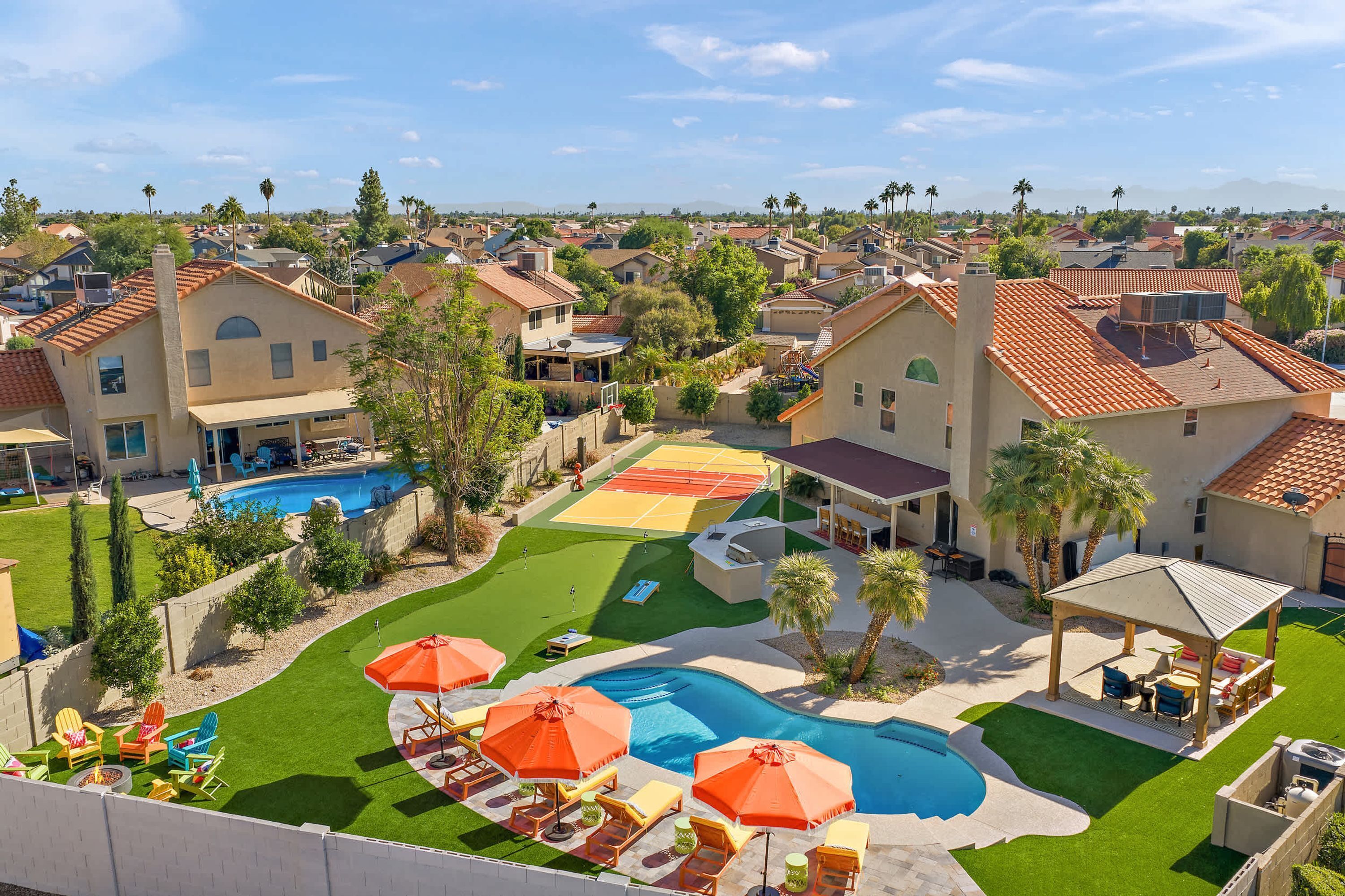 A residential area with houses, a swimming pool, and a tennis court.