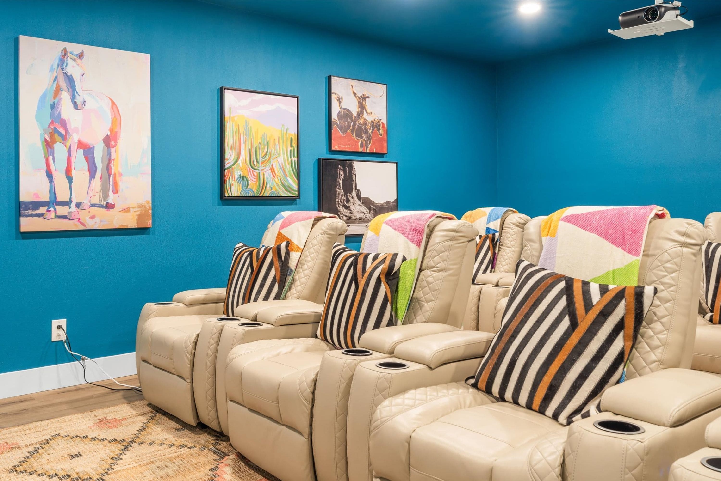A room with a blue wall, a massage chair area, and artwork.
