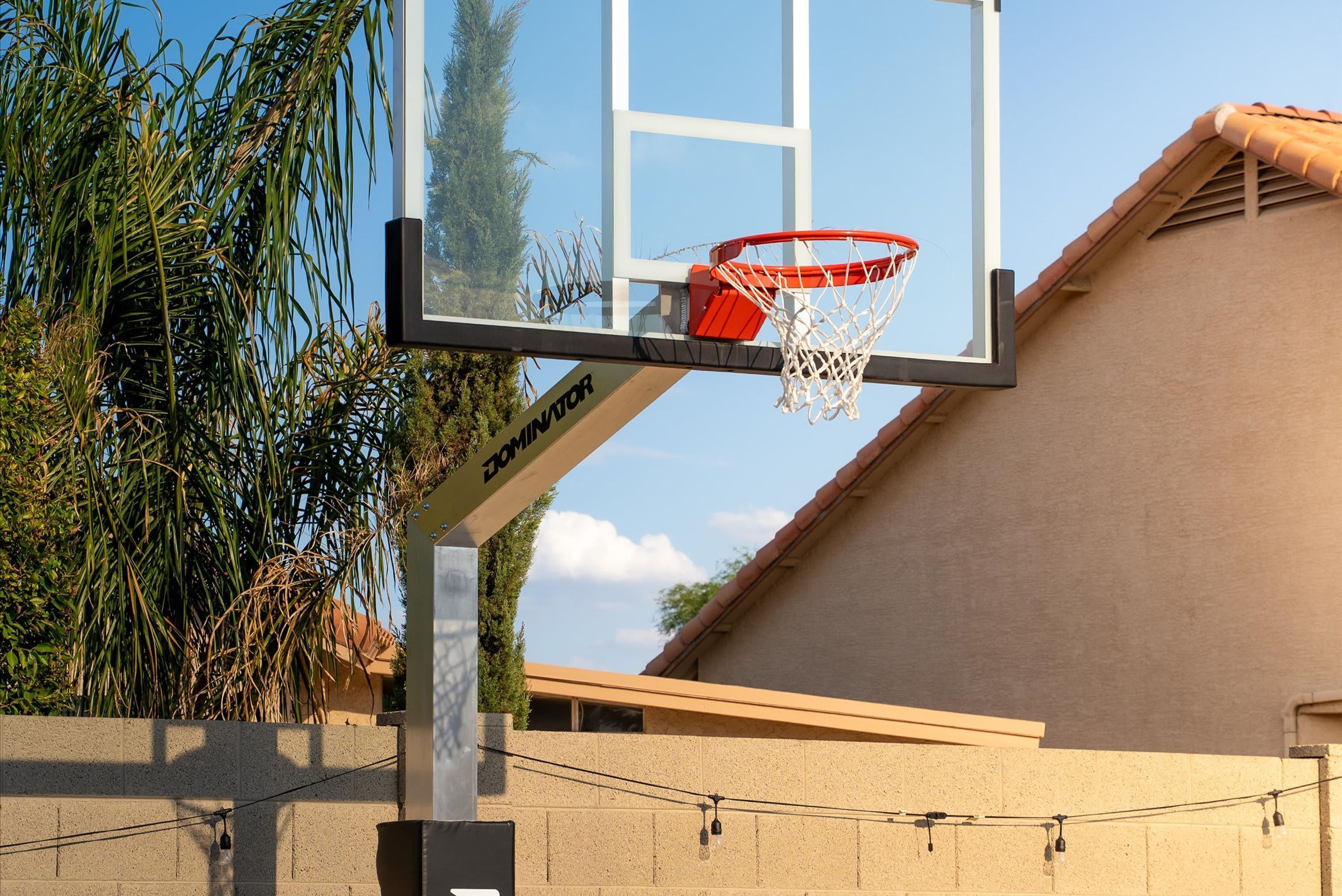 Un aro de baloncesto con red, sujeto a un poste donde se aprecia el nombre de una marca.