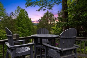 A deck with a table and four Adirondack chairs, surrounded by trees and a view of the sky. - 12 Min to Downtown Sleeps 12 Hot Tub Fire Pit (Blue Ridge)
