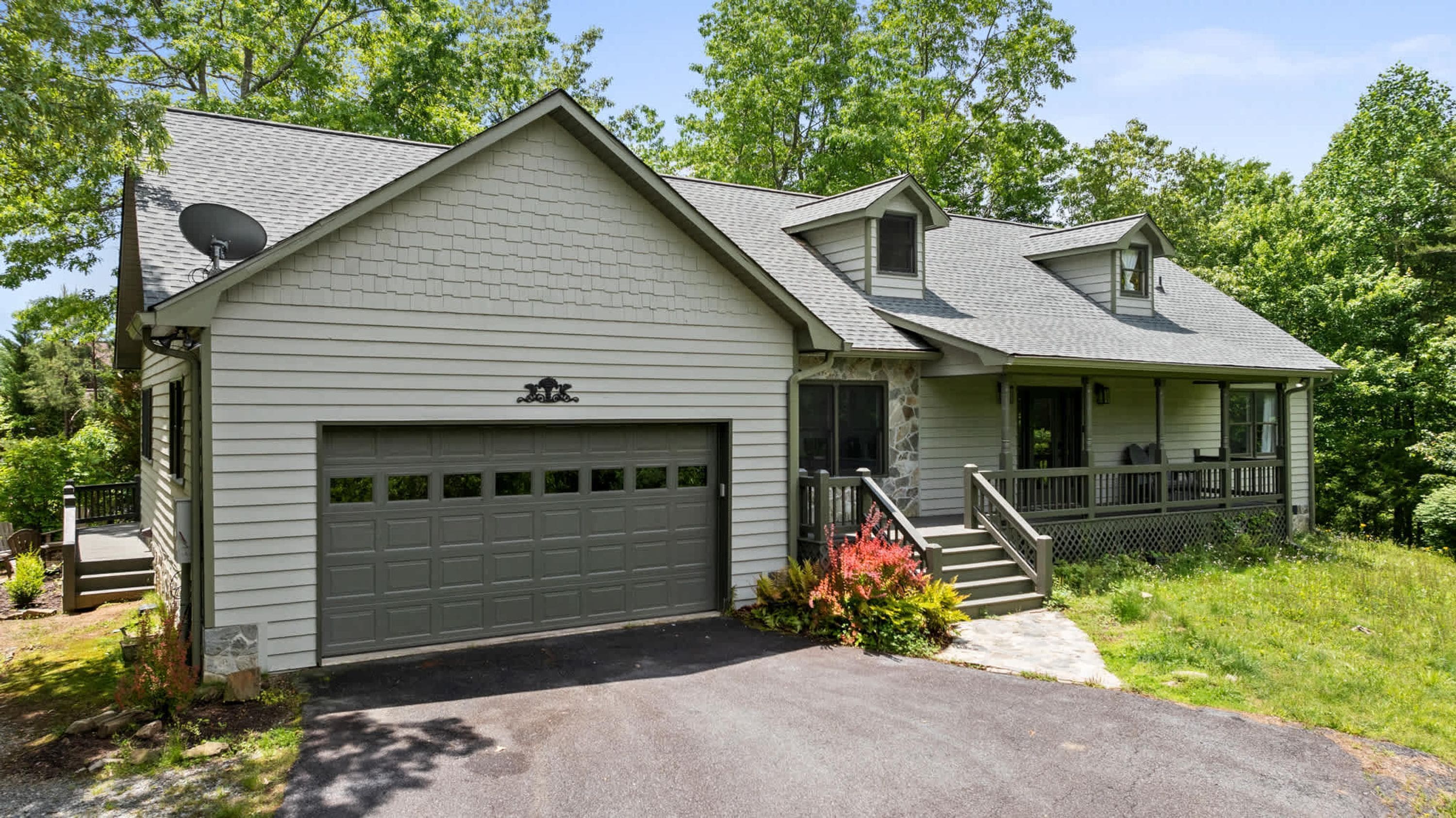 A single-story house with a garage, a covered porch, and a small staircase leading to the entrance.