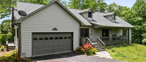 A single-story house with a garage, a covered porch, and a small staircase leading to the entrance.