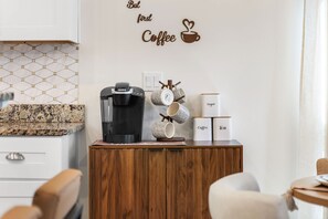 A kitchenette with a coffee maker, mugs, and containers labeled 'Coffee' and 'Tea'. - Royal Palms Arcade Free Beach Shuttle Pool (Destin)