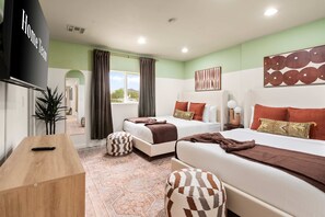 Une chambre d’hôtel avec deux lits, une télévision, une plante et une vue sur l’extérieur.