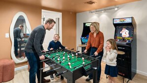 Ett rum med ett fotbollsspel, en tv och en spegel.