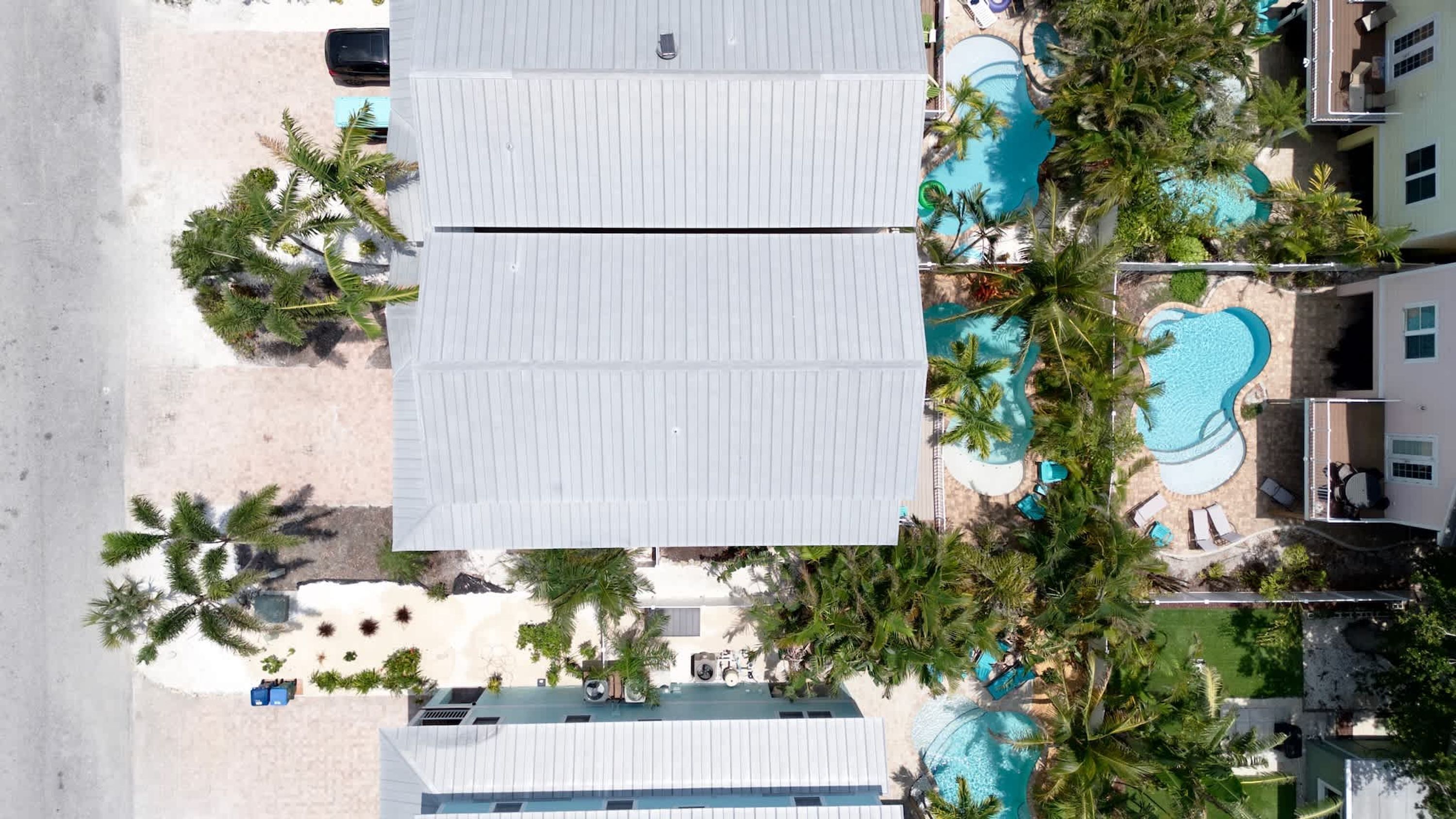 Ein Resort mit mehreren Schwimmpools, Palmen und einer Strandanlage.