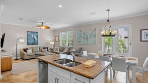 A spacious living area with a kitchen island, dining table, and seating. - Holmes Beach - Pool - Minutes to Beach - Sleeps 8 (Holmes Beach)