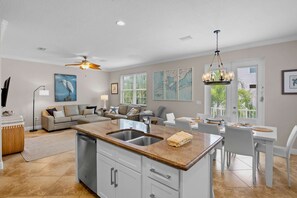 A spacious living area with a kitchen island, dining table, and seating. - Holmes Beach - Pool - Minutes to Beach - Sleeps 8 (Holmes Beach)