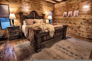 A wooden cabin bedroom with a four-poster bed, two bedside tables, and a window. - Stairway to Heaven 7BR Luxury Mountain Views (Broken Bow)