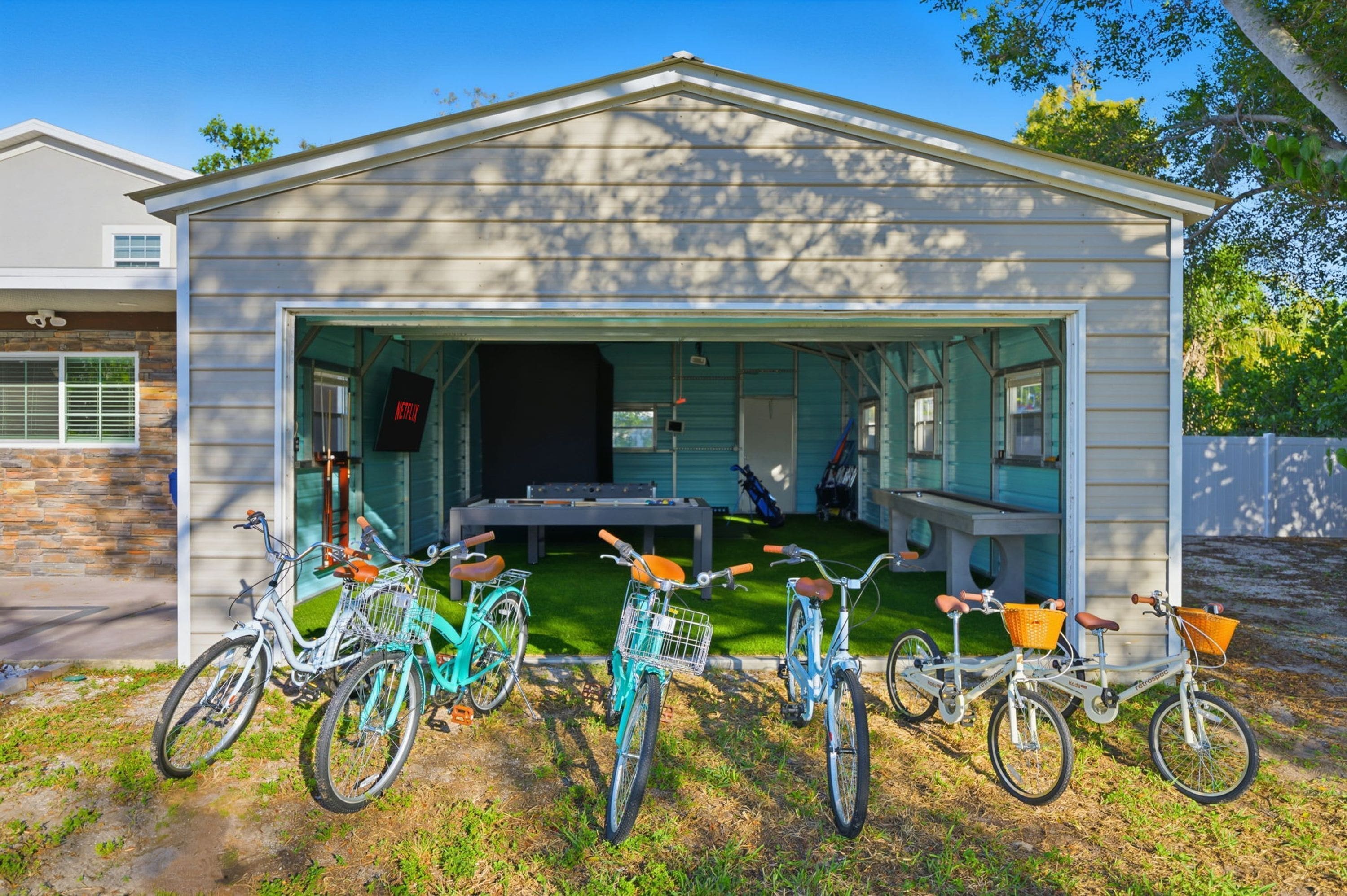 Un bâtiment doté d’un patio couvert, avec plusieurs vélos garés devant et une table avec des chaises à l’intérieur.