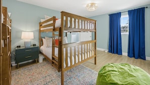 A bunk bed room with a desk, a lamp, and a window with curtains. - Sleeps 16 Golf Simulator Pickleball Pool Spa (Bradenton)