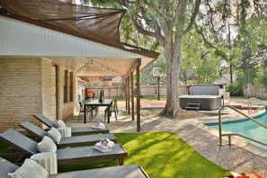 A covered outdoor area with a pool, lounge chairs, and a barbecue grill. - Poolside Pickleball Heated Pool Sleeps 20 (San Antonio)