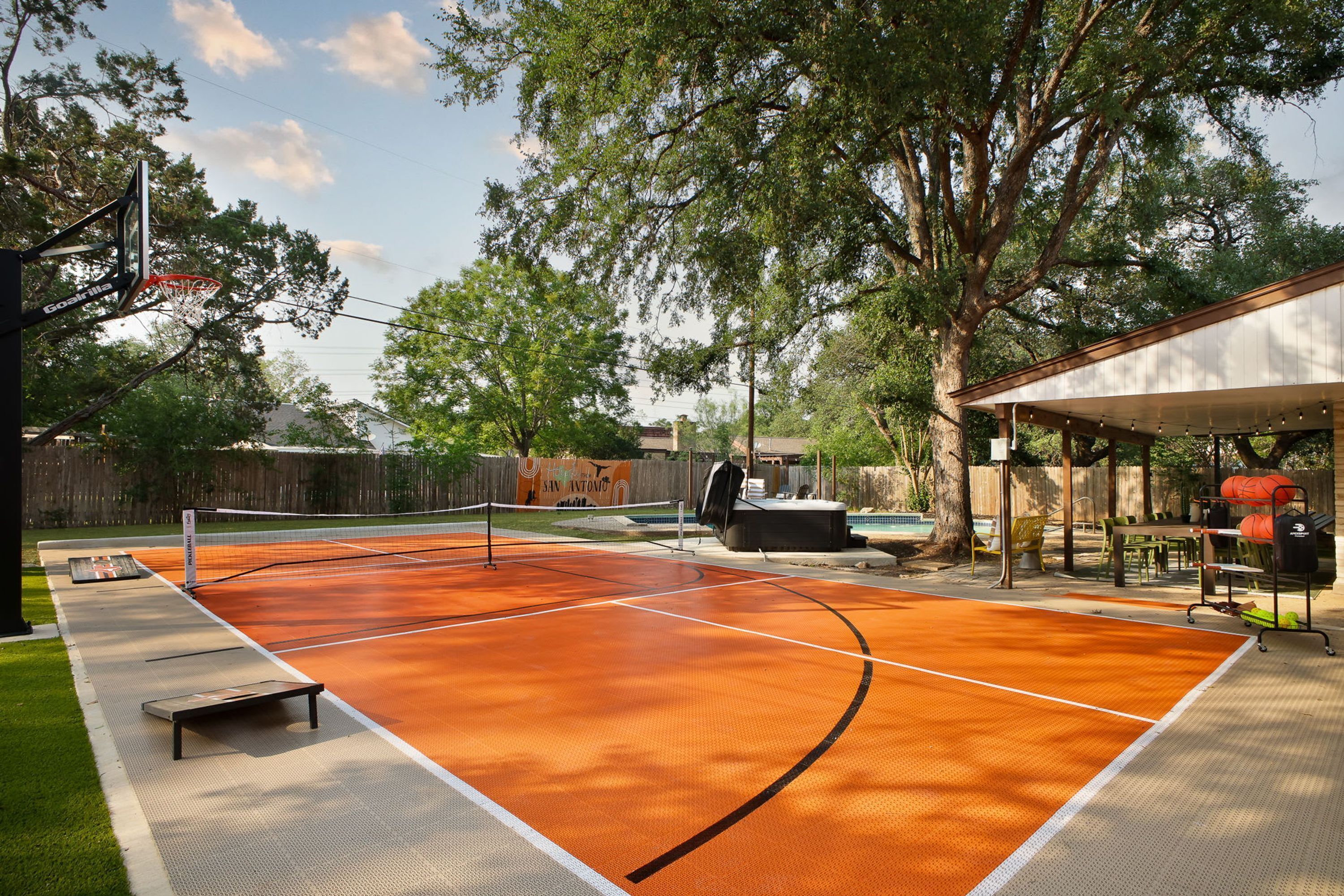 Ein Basketballplatz im Freien mit Korb, Whirlpool und überdachter Sitzgelegenheit.