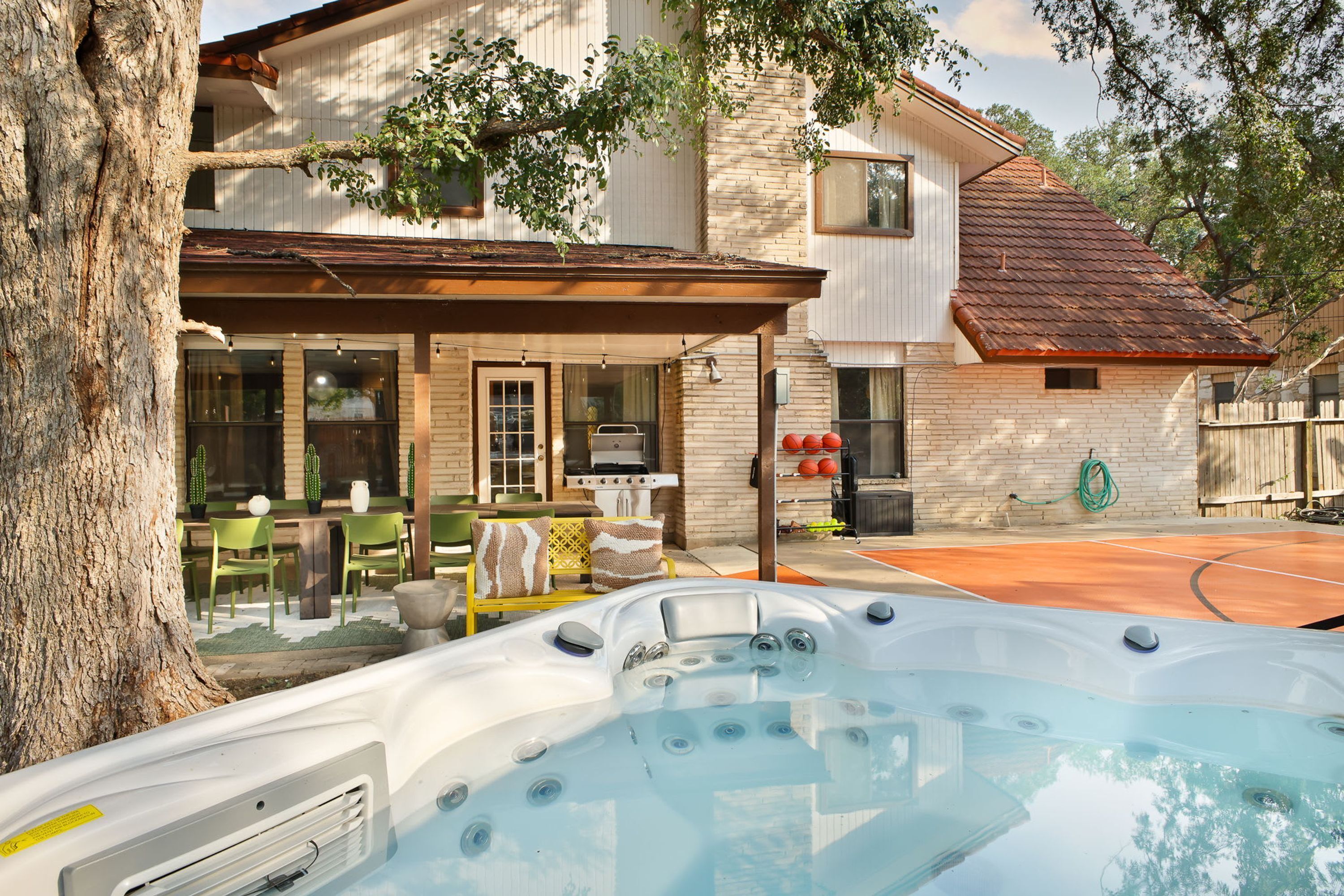 Ein Wohnhaus mit Whirlpool, Sitzgelegenheit im Freien und Grillplatz.