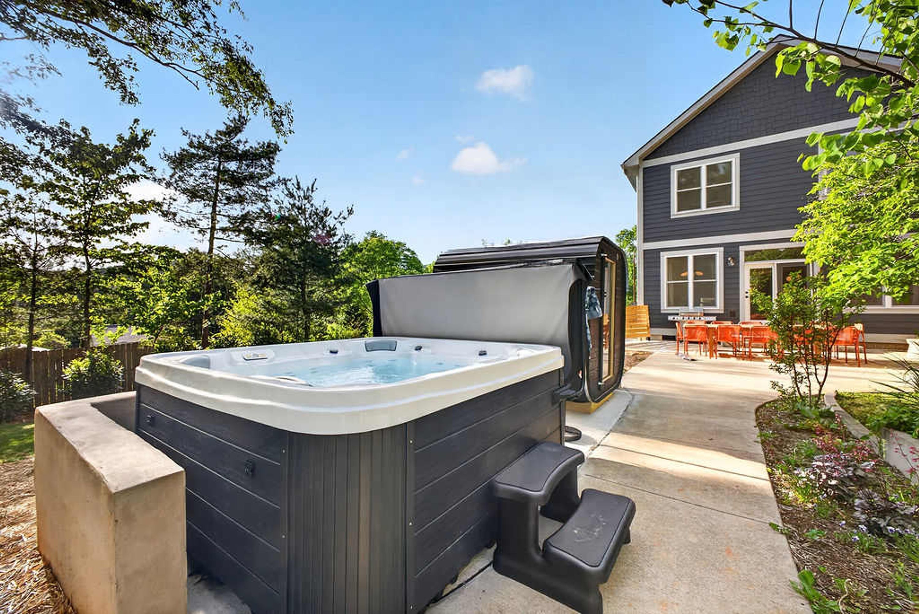 A hot tub in a backyard with a house in the background.