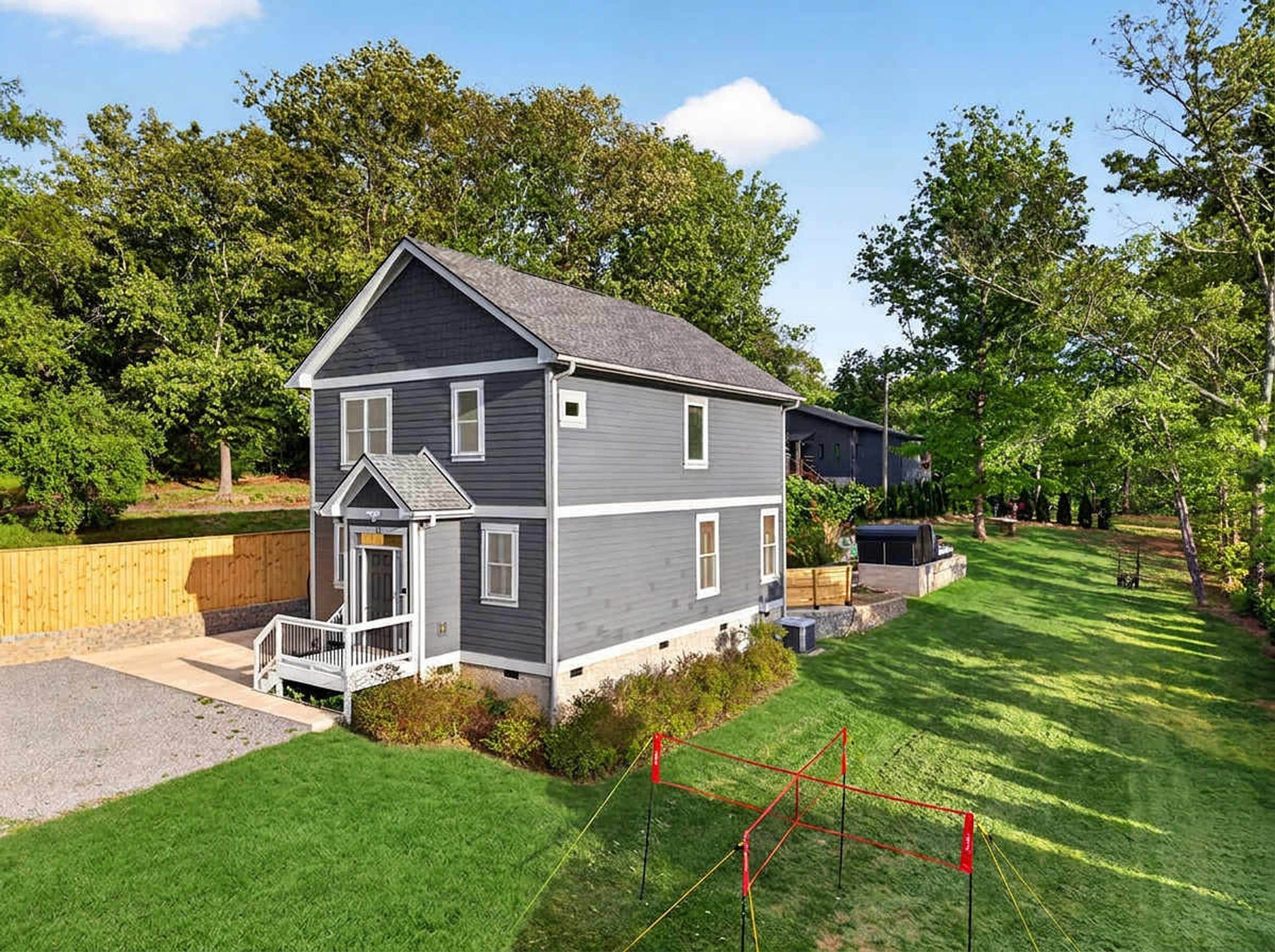 A two-story house with a front porch, a garage, and a well-maintained lawn.