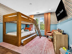 A bunk bed room with a wooden frame, a desk with books, and a television labeled 'Home Team'. - Outdoor Games Hot Tub Firepit Grill Sauna (Asheville)