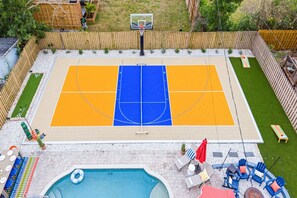 An outdoor basketball court with a pool and lounge area. - Palm Shell Villa - Pool - Pickleball - Hot Tub (Bradenton)