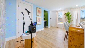 Een moderne woonkamer met houten vloer, een grijze bank, een houten salontafel en een groene plant.