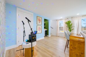 A modern living room with a wooden floor, a grey sofa, a wooden coffee table, and a green plant. - Palm Shell Villa - Pool - Pickleball - Hot Tub (Bradenton)