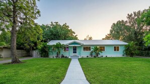 A single-story house with a front yard and a sidewalk leading to the entrance. - Kokomo House Pool Hot Tub Outdoor Games (Bradenton)