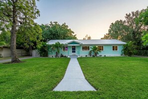 A single-story house with a front yard and a sidewalk leading to the entrance. - Kokomo House Pool Hot Tub Outdoor Games (Bradenton)