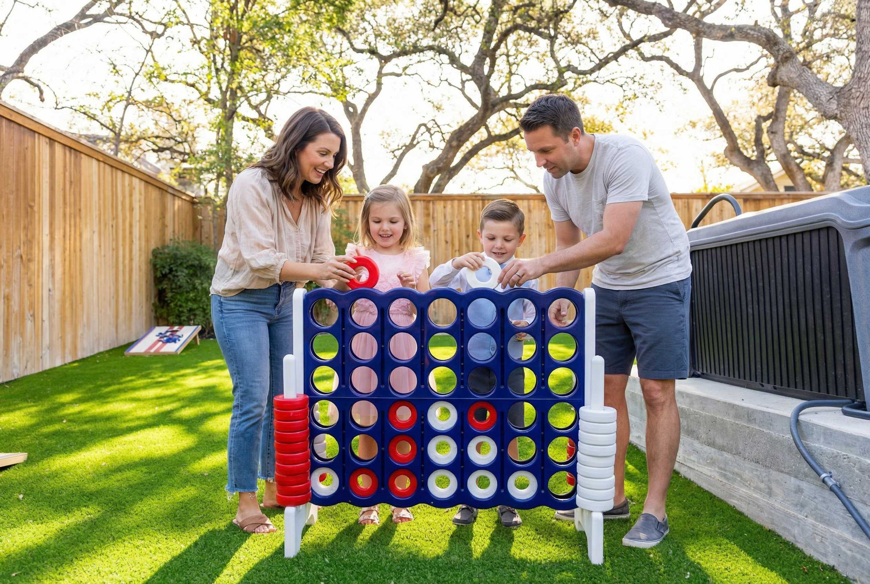 A family playing a lawn game in a backyard with a wooden fence and trees.