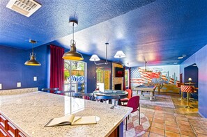 A room with a bar area, a fireplace, and a mural with a desert theme. - Cowboy Ridge 4BR Spacious Retreat Sleeps 13 (San Antonio)