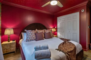 Ein Schlafzimmer mit einem großen Bett, zwei Nachttischlampen, einem Deckenventilator und einem Kleiderschrank.