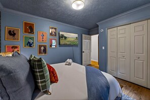 A bedroom with a bed, pillows, a flat-screen TV, and a door leading to another room. - Wellsprings Retreat Smoky Mtn Views Sleeps 12 (Gatlinburg)