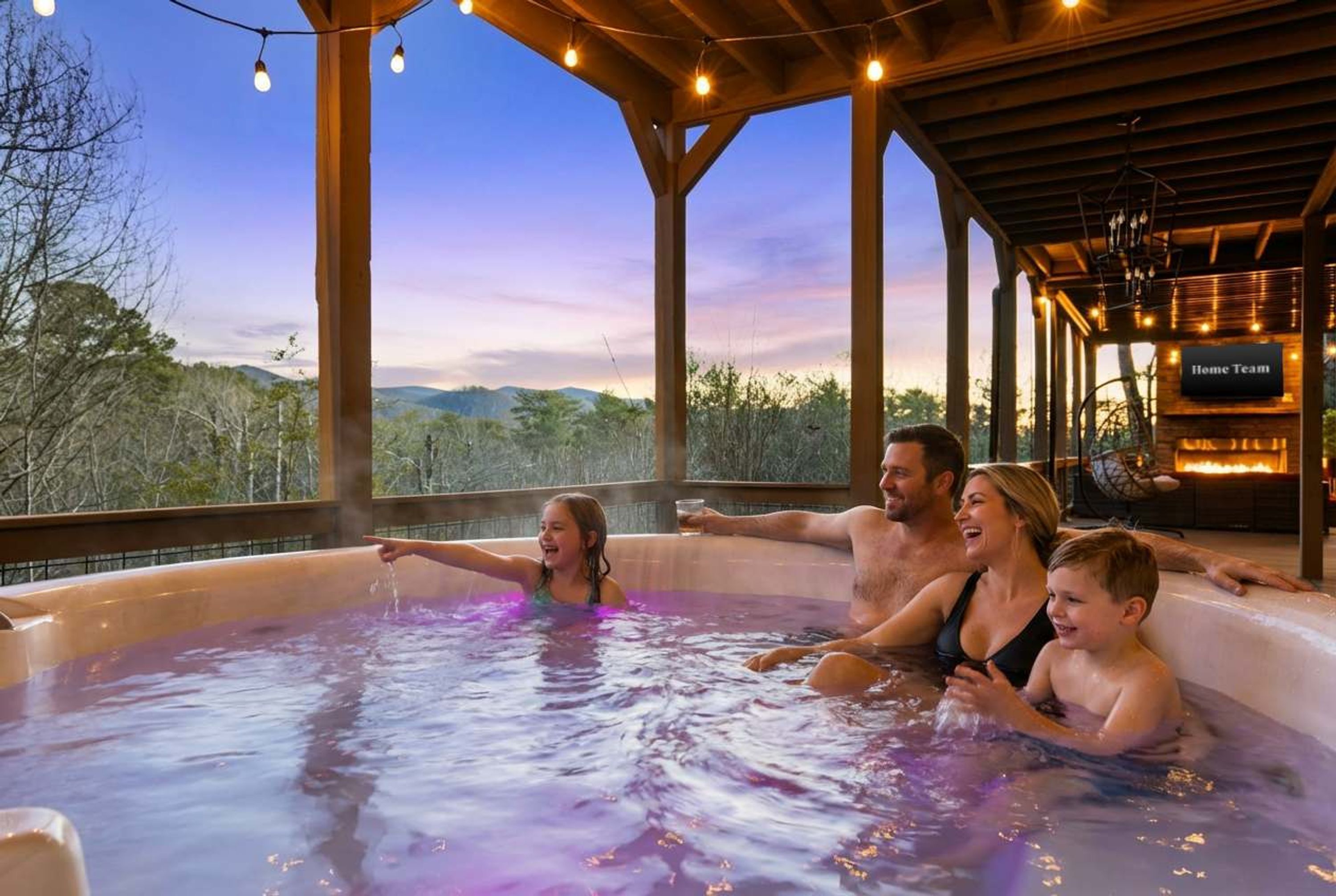 Une famille se détend dans un jacuzzi et profite de la vue sur les montagnes.