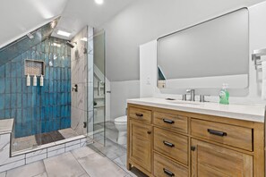 A modern bathroom with a shower, toilet, vanity, and a large mirror. - Mtn Views Theater Hot Tub 5 King Suites (Blue Ridge)