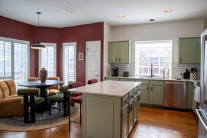Une cuisine avec un coin repas, comprenant une table ronde, des chaises et un tapis.