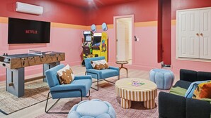 Ein Zimmer mit einem Kicker, einem Flachbildfernseher und einer PlayStation 4 Konsole.