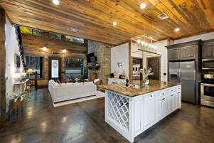Una cocina moderna con una isla central, electrodomésticos de acero inoxidable y una pared de acento de piedra.