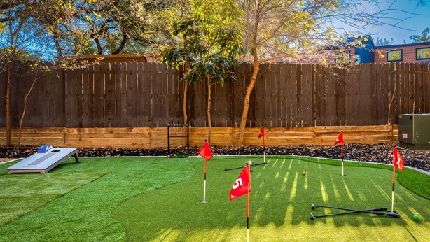 Ein Garten mit Kunstgrasanlage, Putting-Green und Holzzaun.