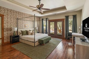 A bedroom with a four-poster bed, a desk, and a view of the outdoors. - Stillstone Ranch A Wellness Retreat Sleeps 32 (Driftwood)