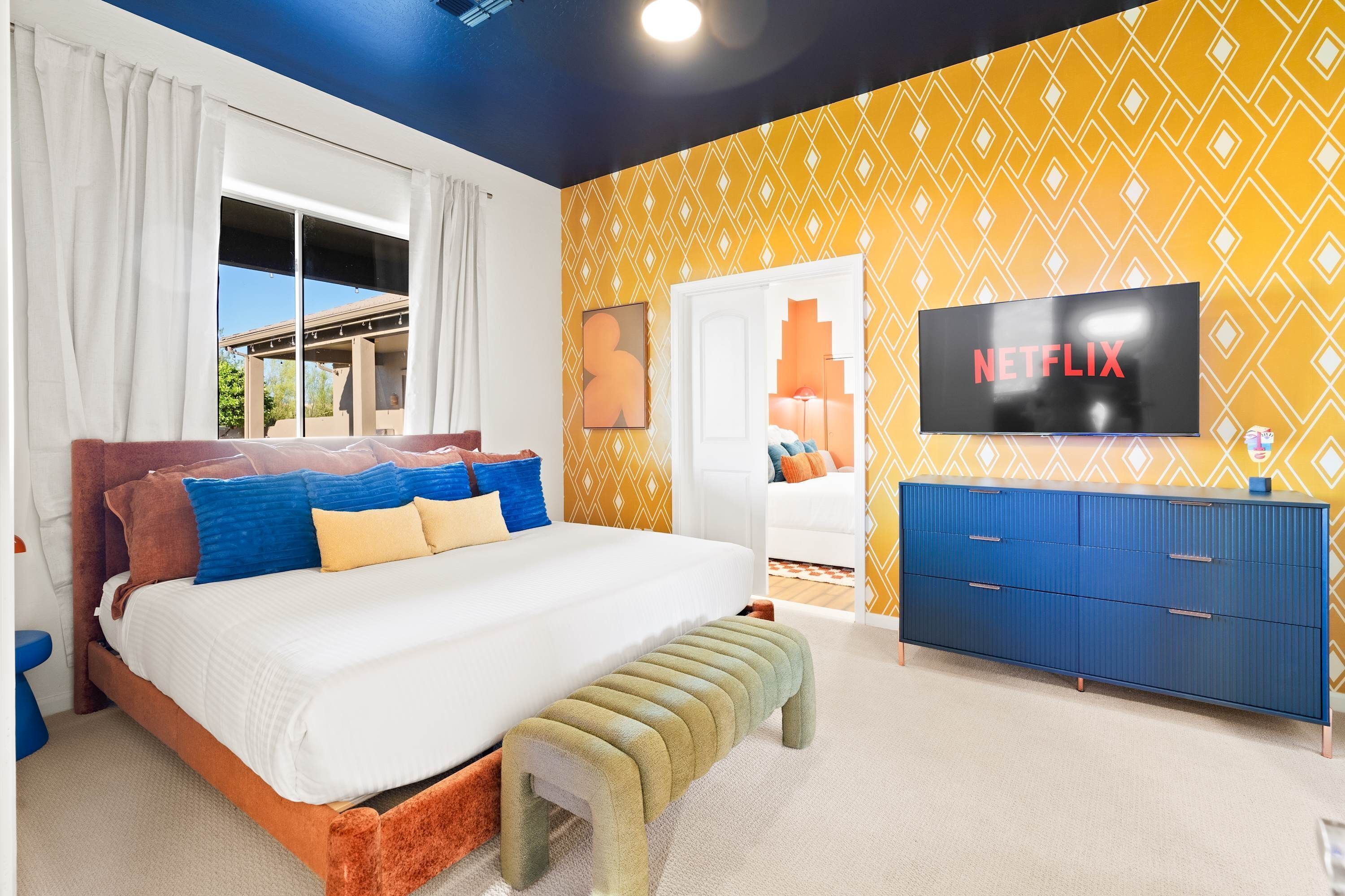 Une chambre à coucher avec un lit, une télévision, une armoire et une fenêtre.