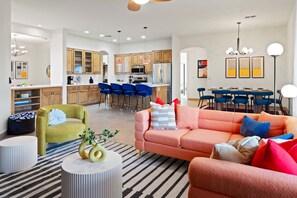 A modern living room with a sofa, chairs, a coffee table, and a striped rug. - Suncrest Retreat - Pool Pickleball Theater (Scottsdale)
