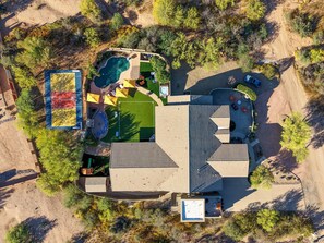 An aerial view of a property with a swimming pool, tennis court, and outdoor seating areas. - Suncrest Retreat - Pool Pickleball Theater (Scottsdale)